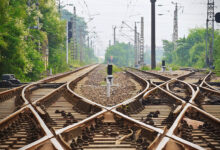A train tracks with a cross between them