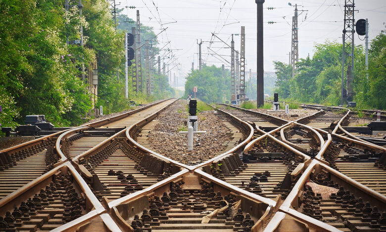 A train tracks with a cross between them
